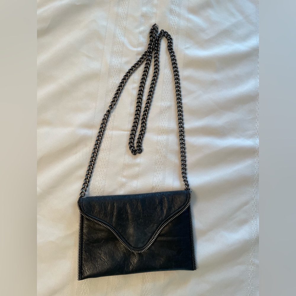 Black vegan leather with silver zipper detail. Heavy chain.